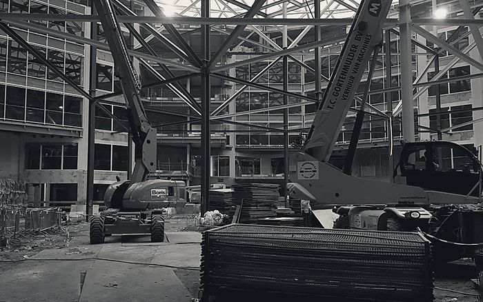 Uitvoering in een grote hal met hoogwerkers onder een stalen dakconstructie